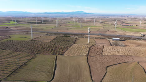 Felder,-Windkraftanlagen,-Vogelschwarm-Und-Berge,-Luftaufnahmen,-Sonniger-Tag,-Spanien